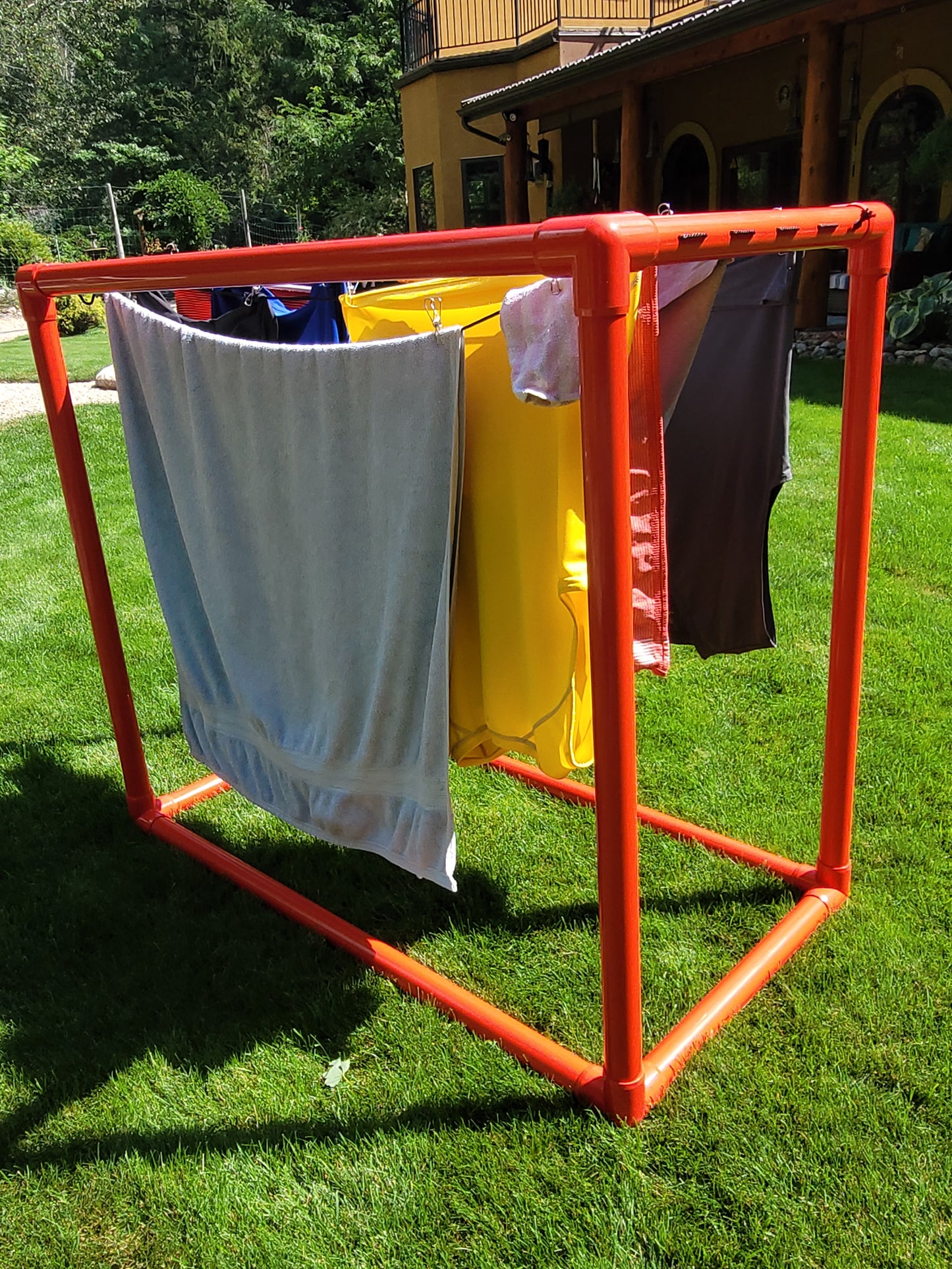 Red PVC clothes dryer on lawn